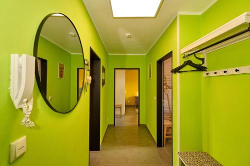 a bathroom with green walls and a mirror at Eifelgold Ferienwohnung in Daun
