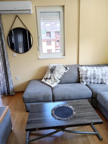 a living room with a couch and a coffee table at Apartmani Pezerović in Soko Banja