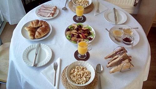 een witte tafel met borden eten en drinken bij Bed & Breakfast Only - not 24 hour lodging - Truro, Cornwall - free parking in Truro