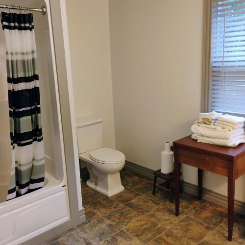 a bathroom with a toilet and a table with towels at 6 Olivia Lane in Deer Lake