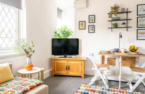 a living room with a tv and a desk with a table at #09 Stylish 2 bed Apart - Sleep 5 - fast Wi-fi - BHX NEC- " Perfect for Contractors and Families - Free Parking" in Shirley