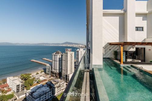 a view of the ocean from the balcony of a building at MHFA - Studios em Prédio Luxuoso com Vista Mar in Itapema