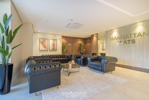 a waiting room with leather couches and a sign at MHFA - Studios em Prédio Luxuoso com Vista Mar in Itapema