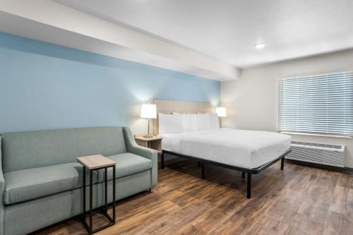 a hotel room with a bed and a couch at WoodSpring Suites Savannah West - Ellabell Metaplant in Ellabell