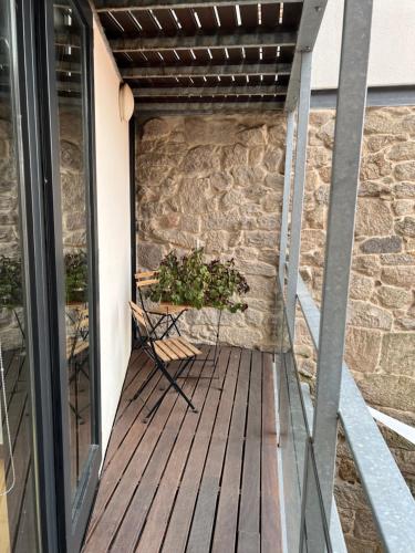 a balcony with a chair on a wooden deck at Pensión rural Pallabarro in Allariz