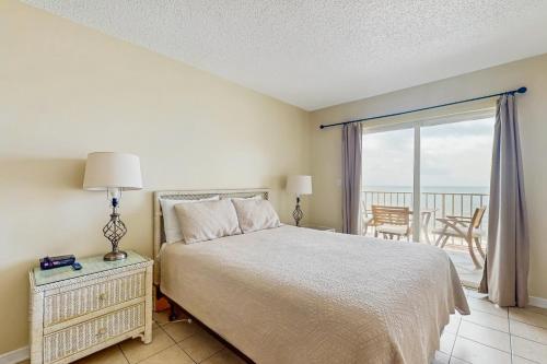 a bedroom with a bed and a view of the ocean at Ocean House I 1702 in Gulf Shores
