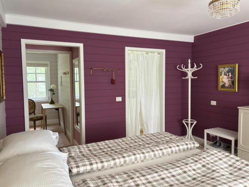 a bedroom with purple walls and a bed in it at A Calm & Quiet Stay in Wuustwezel