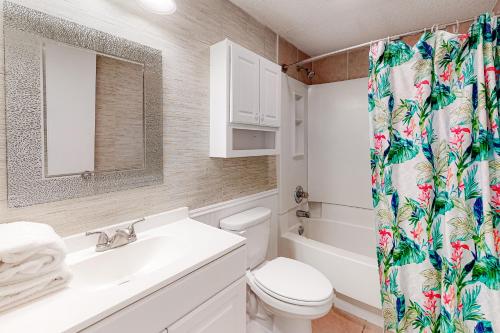 a bathroom with a toilet and a sink and a shower curtain at Emerald Skye 42 in Orange Beach