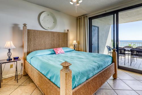 a bedroom with a large bed and a balcony at Windward Pointe 306 in Romar Beach