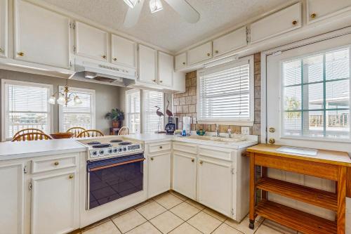 a kitchen with white cabinets and a stove top oven at Bay Side Believer in Dauphin Island