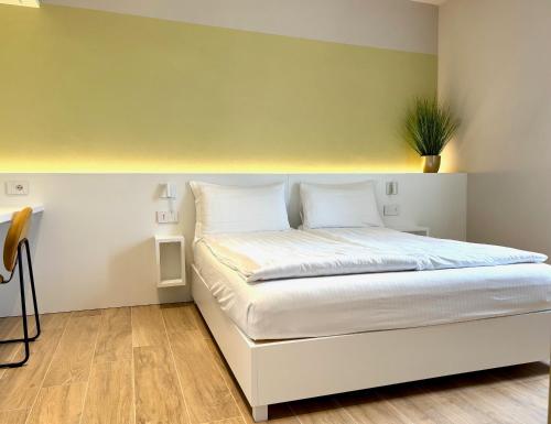a bedroom with a white bed with a plant on it at Appartamenti BETTELONI in Bardolino