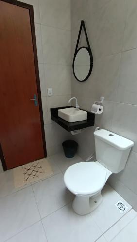 a bathroom with a white toilet and a sink at Sua casa pertinho da praia in Camocim