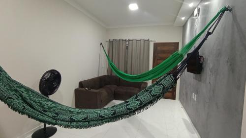 a hammock in a living room with a couch at Sua casa pertinho da praia in Camocim