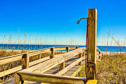 a wooden boardwalk to the beach with the ocean in the background at Four Winds 701 in Romar Beach