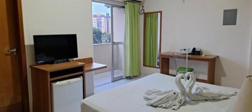 a hotel room with a bed and a flat screen tv at Golden Dolphin Grand Hotel in Caldas Novas