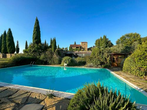 a large blue swimming pool in a yard with trees at Historic Villa Among Olive Groves In Arezzo in San Polo