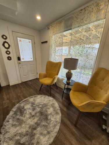 a living room with two chairs and a table at Nimo Homestay , New Entire Studio Apartment Guelph in Guelph