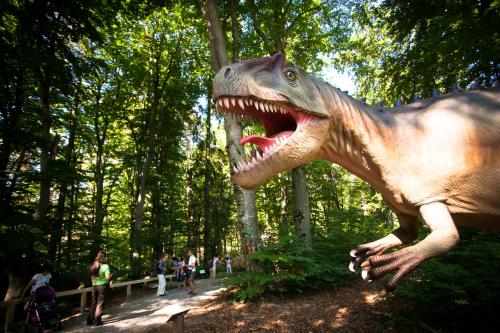 a dinosaur statue of a dinosaur in a park at Lux Garden Hotel in Azuga