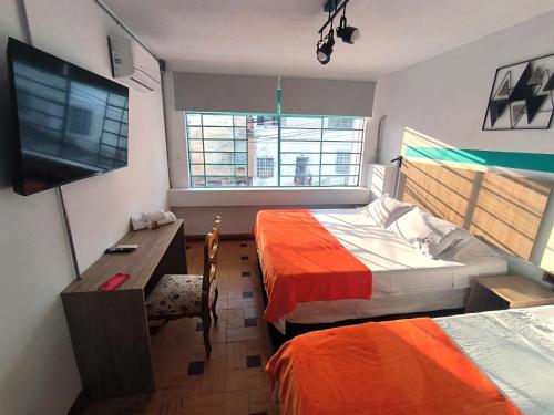 a hotel room with two beds and a television at HOTEL CASA VECCHIA San Antonio in Cali