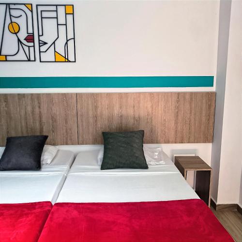 a bedroom with a white bed with a red blanket at HOTEL CASA VECCHIA San Antonio in Cali