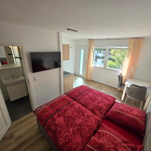 a bedroom with a bed with a red comforter at Gemütliches und komfortables Studio in Frankfurt in Frankfurt