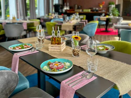 a table with plates of food and wine glasses at Malinowski Leśny in Gliwice