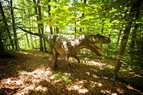 a statue of a dog standing in the woods at Lux Garden Hotel in Azuga