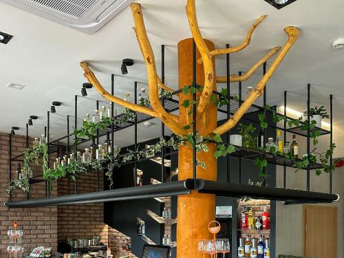 a chandelier in a bar with ivy at Malinowski Leśny in Gliwice