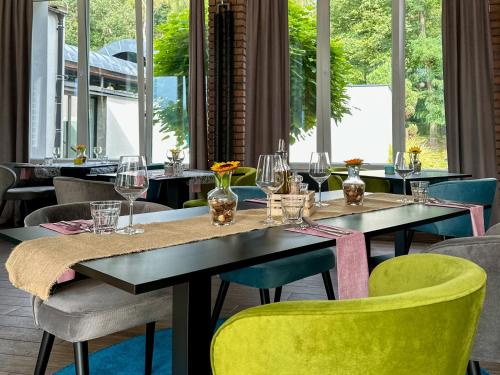 a dining room with tables and chairs and windows at Malinowski Leśny in Gliwice