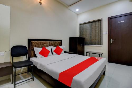 a bedroom with a bed and a desk and a chair at Hotel O The Shloka in Bhopal