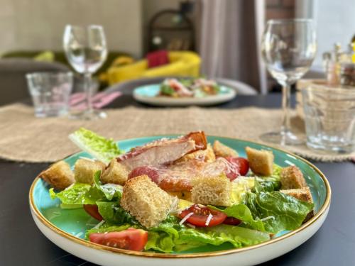 a plate of salad with meat and vegetables on a table at Malinowski Leśny in Gliwice