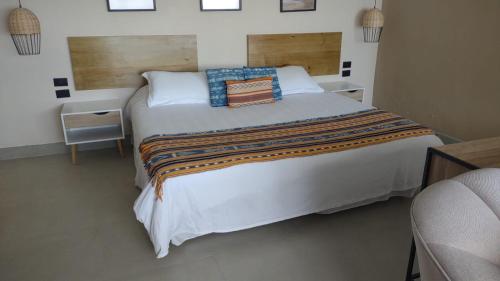 a bedroom with a large white bed with pillows at Atitlan Sunset Lodge in Santa Cruz La Laguna