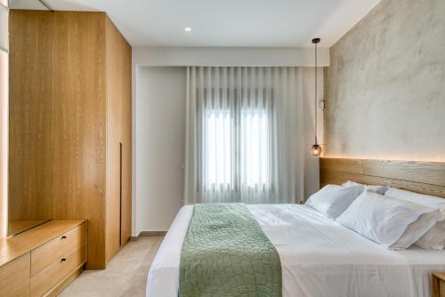 Un dormitorio con una cama grande y una ventana. en Elena's Sunset Villa, en Piryiótika