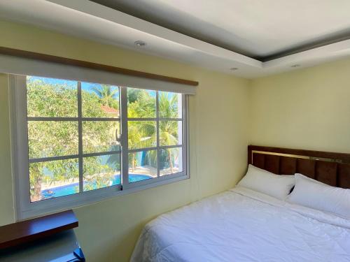 a bedroom with a bed and a large window at Our Home Zudelyn SRL in Los Frailes