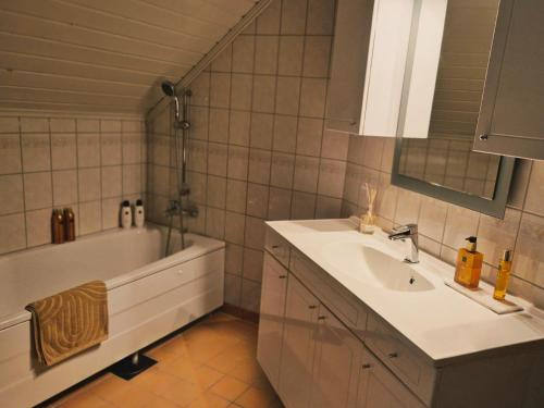a bathroom with a sink and a bath tub and a sink at Trines Hjerterom in Steinkjer
