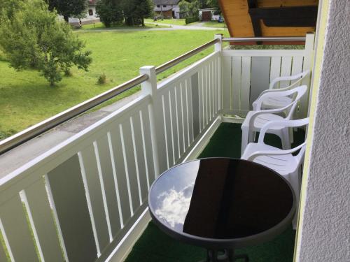 a balcony with a table and chairs and a field at Ferienhaus Andrä in Hermagor