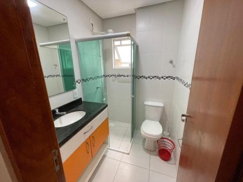 Un baño con inodoro, lavabo y espejo. en cód 39 · Apartamento com vista mar, en Governador Celso Ramos
