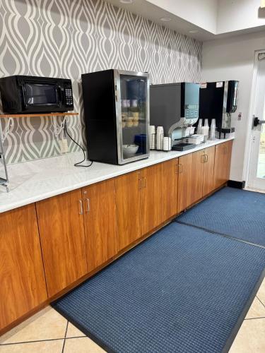 a kitchen with wooden cabinets and microwaves at Microtel Inn & Suites by Wyndham Port Charlotte Punta Gorda in Port Charlotte