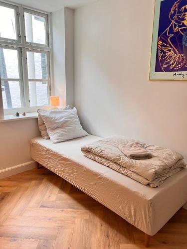 a bed sitting in a room with a window at Central Odense Hideaway – Courtyard Apartment in Odense