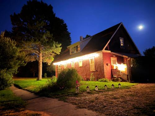 a house with lights on the front of it at night at 1912 Nostalgic TrainCrew Boarding House in Potter