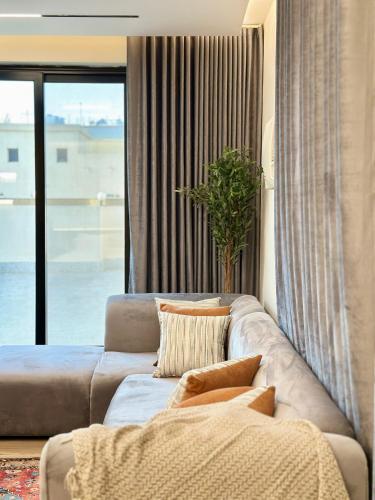 ジッダにあるاستديو فندقي فاخر بإطلالة وبتصميم راقيのソファと大きな窓のあるリビングルーム