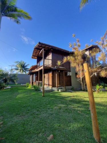 a house with a palm tree in front of it at Casa da Karina in Arraial d'Ajuda