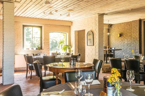 a restaurant with tables and chairs in a room at Sparhof in Dranouter