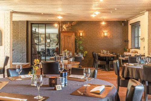 a restaurant with tables and chairs in a room at Sparhof in Dranouter