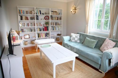a living room with a couch and a table at Villa Camélias, appartements de Charme in Mittelwihr