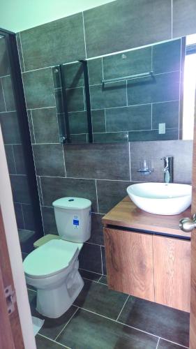 a bathroom with a toilet and a sink at Hotel VILLA CABAÑA in Villagarzón