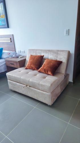 a couch in a living room with two pillows on it at Hotel VILLA CABAÑA in Villagarzón