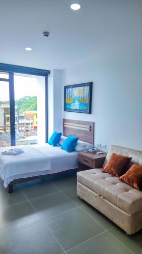 a bedroom with a large bed and a couch at Hotel VILLA CABAÑA in Villagarzón