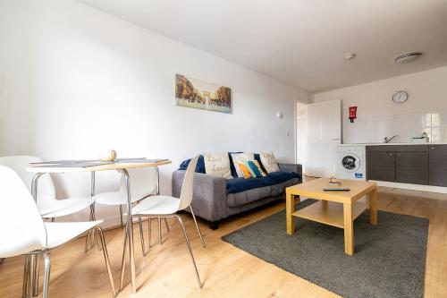 a living room with a couch and a table at 2 Bedroom Large First Floor Apartment with FREE Parking in Loughborough