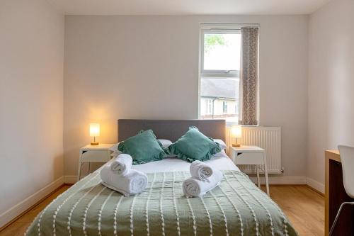 a bedroom with a bed with towels on it at 2 Bedroom Large First Floor Apartment with FREE Parking in Loughborough